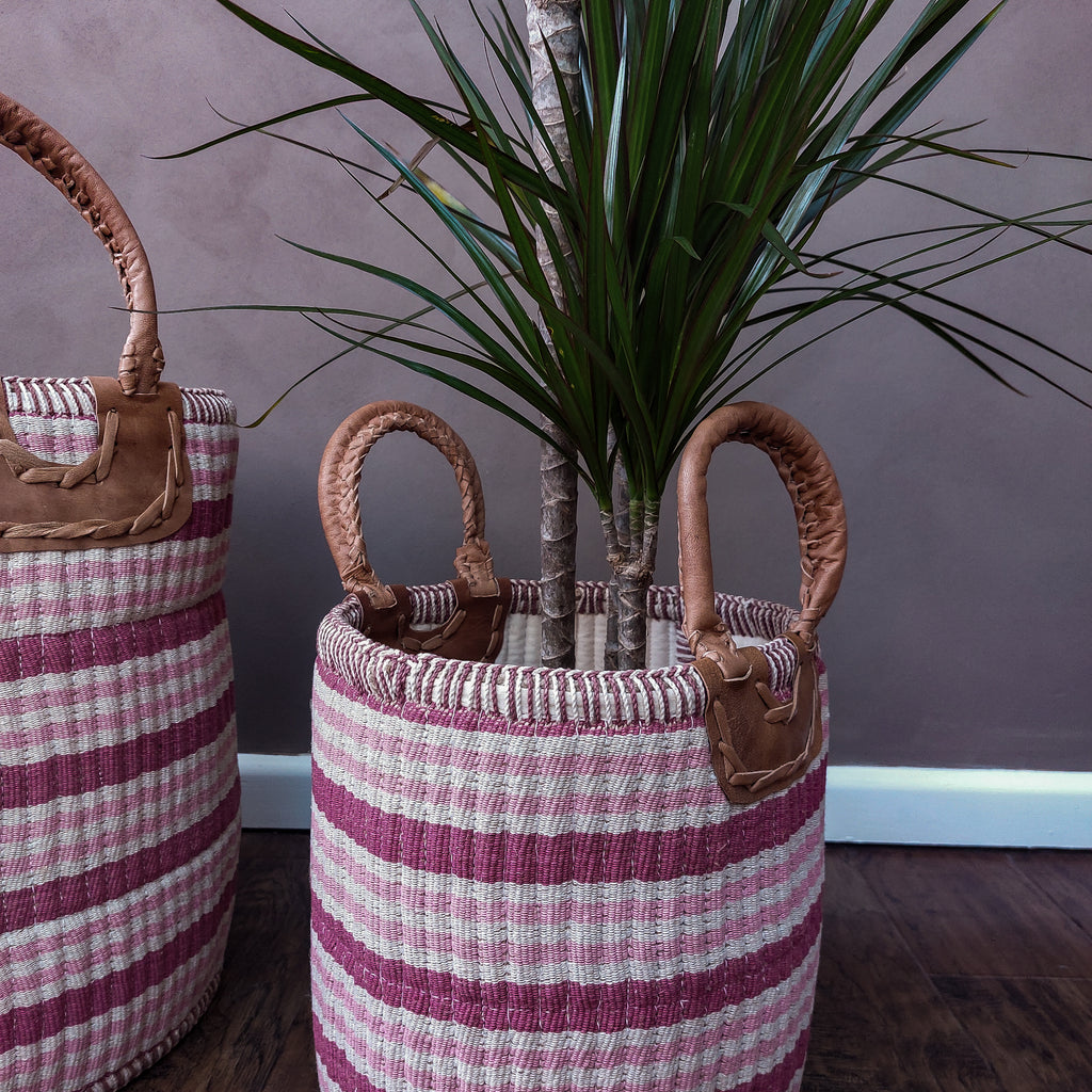 two Gulabi Striped Pink Cotton & Jute Handloom Baskets on a wooden floor.