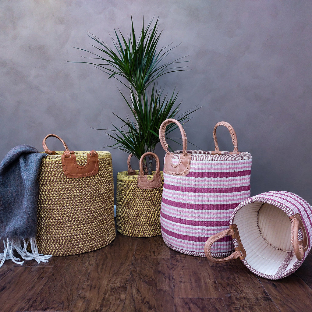 three Gulabi Striped Pink Cotton & Jute Handloom Baskets with handles on a wooden floor.
