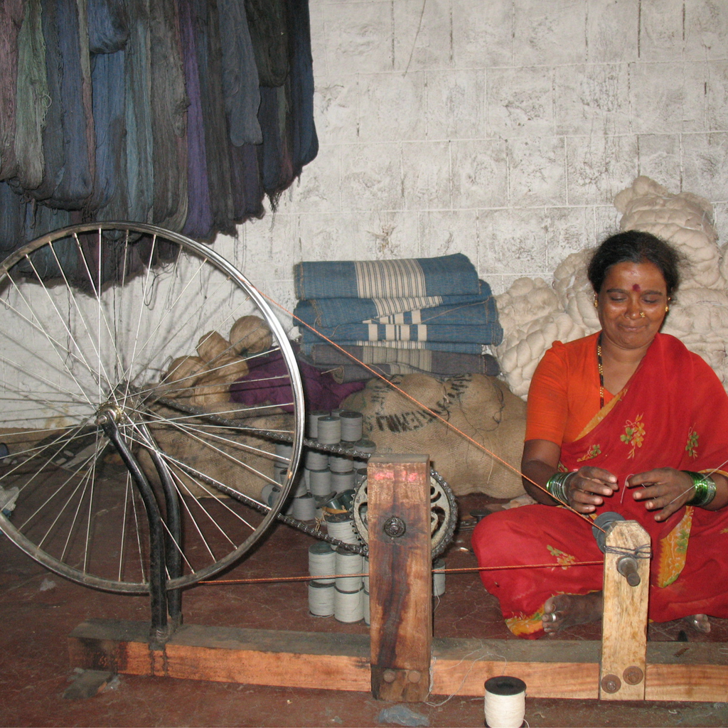 a woman sitting on a Gulabi Striped Pink Cotton & Jute Handloom Basket.