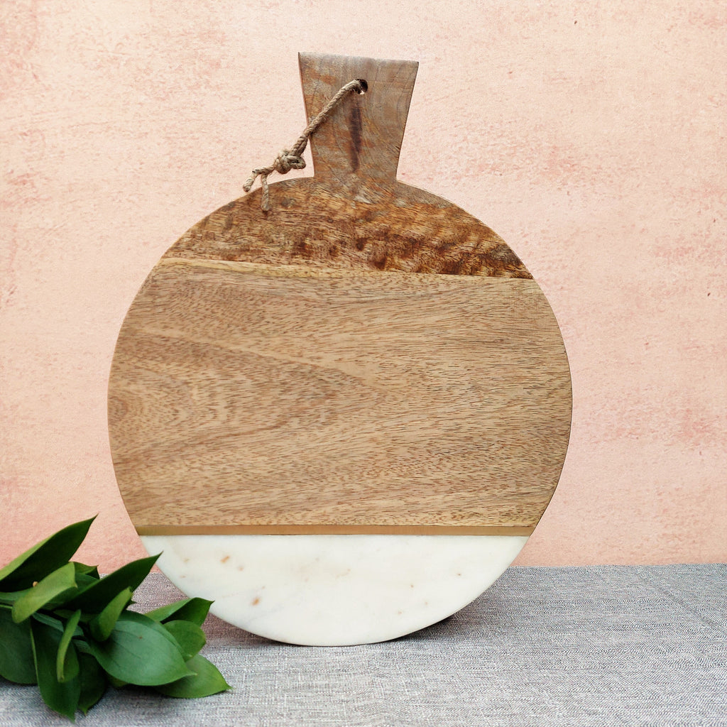 a Dusheri Round Wood & Marble Cheese/Chopping Board with a plant on it.