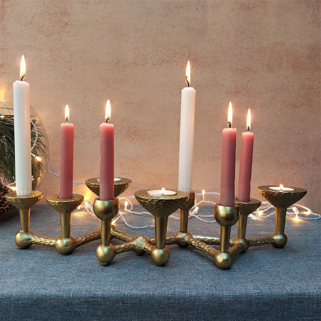 A Deeya Multi candle Centrepiece Candelabra on a table next to a christmas tree.