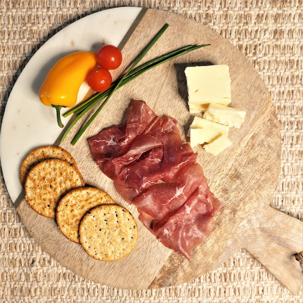 Dusheri Round Wood & Marble Cheese/Chopping Board, cheese and crackers on a wooden board.