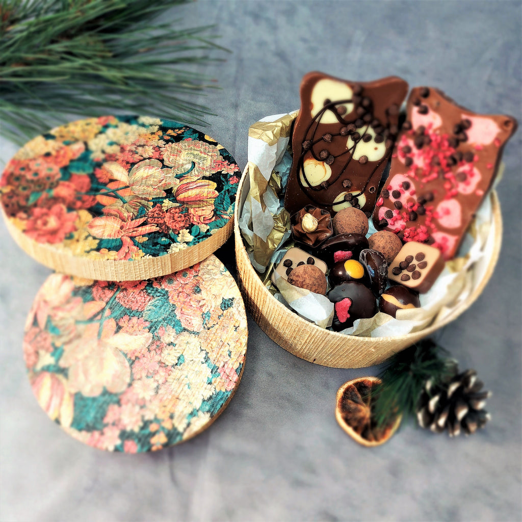 a Kela Round Storage box - Blue Floral filled with chocolates, nuts and pine cones.